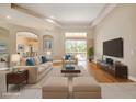 Spacious living room featuring a tray ceiling, large windows, and stylish neutral-toned furniture at 2773 Harvest Dr, Sarasota, FL 34240