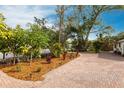 Paver driveway with lush landscaping and mature trees leads to the home's entrance at 2826 Marlette St, Sarasota, FL 34231