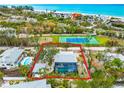 Beautiful aerial view of beach home featuring a screened-in pool and spa with lush landscaping and nearby beach access at 531 Edlee Ln, Longboat Key, FL 34228