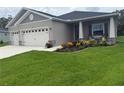 Charming single-Gathering home with a three-car garage and a beautiful landscaped yard with colorful flowers at 6614 162Nd E Pl, Parrish, FL 34219