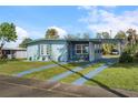 Charming single-story home featuring a carport, blue exterior, and well-maintained front yard at 8466 Maureen Ave, North Port, FL 34287