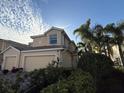 Two-story townhome featuring a two-car garage, well-maintained landscaping, and a beautiful sky at 1274 Burgos Dr # 1101, Sarasota, FL 34238