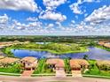 Aerial view of a home with a tile roof situated on a large lot with a pond in a beautiful neighborhood at 20686 Valprato Ct, Venice, FL 34293