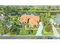 Beautiful single-story home with a clay tile roof and lush landscaping near a tranquil canal at 4221 Escondito Cir, Sarasota, FL 34238