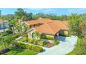 Attractive single-story home with clay tile roof, long driveway, and well-maintained landscaping at 4221 Escondito Cir, Sarasota, FL 34238