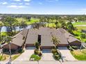 Aerial view of the townhome complex showcasing manicured landscaping and a serene lake at 5724 Doral Dr, Sarasota, FL 34243