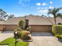 Close up of the exterior showcasing a two-car garage and well-maintained landscaping at 5724 Doral Dr, Sarasota, FL 34243