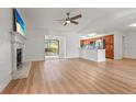 Bright, open living room with a fireplace, ceiling fan and hardwood flooring that flows to the kitchen at 7507 3Rd Nw Ave, Bradenton, FL 34209