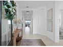 Inviting entryway with tile flooring, decorative console table and wreath, providing a warm welcome at 1889 Saddlewood Cir, Port Charlotte, FL 33953