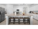 Spacious kitchen island with granite countertops, seating for four, and modern stainless steel appliances at 1889 Saddlewood Cir, Port Charlotte, FL 33953