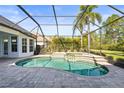 Screened-in pool features a waterfall, spa, and tropical landscaping at 6815 Turnberry Isle Ct, Lakewood Ranch, FL 34202