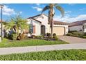 Charming single-story home with a two-car garage, tile roof, and lush tropical landscaping at 23703 Waverly Cir, Venice, FL 34293