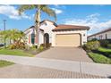 Charming single-story home with a two-car garage, tile roof, and lush tropical landscaping at 23703 Waverly Cir, Venice, FL 34293