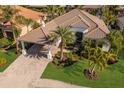 Beautiful home with a tile roof, porte-cochere, lush landscaping, and paver driveway at 579 Fore Dr, Bradenton, FL 34208