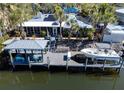 Waterfront home featuring a private dock, boat, outdoor seating, and solar panels on the roof at 903 20Th W Ave, Palmetto, FL 34221