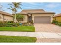 Charming one-story home with a brick driveway, two-car garage, and lush landscaping at 13925 Miranese St, Venice, FL 34293