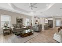 Open concept living room with wood-look tile flooring and view into the kitchen at 3325 Azurite Way, Bradenton, FL 34211