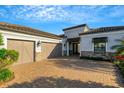 Charming home featuring a spacious two-car garage and stone accents, complemented by a brick driveway at 5341 Greenbrook Dr, Sarasota, FL 34238