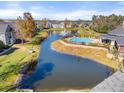 Aerial view of community pool and pond, surrounded by townhomes at 5711 Soldier Cir # 204, Sarasota, FL 34233