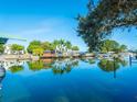 Scenic waterfront view featuring calm, reflective water, lush greenery, and neighboring docks at 121 Holly Ave, Sarasota, FL 34243