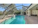 Screened-in pool area featuring a custom pool with calming water features and a comfortable seating area at 12471 Natureview Cir, Bradenton, FL 34212