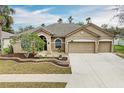 Attractive single-story home featuring a well-maintained lawn, mature landscaping, and a three-car garage at 4306 Douglas Hill Pl, Parrish, FL 34219