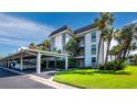 Exterior showcasing covered parking, lush landscaping, and the building's architectural details at 4350 Chatham Dr # E106, Longboat Key, FL 34228