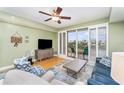 Bright living room with wood floors, ceiling fan, and sliding door to balcony at 559 Bahia Beach Blvd, Ruskin, FL 33570