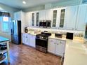Well-lit kitchen featuring white cabinets, stainless steel appliances, and modern backsplash at 7619 Teal Trace, Bradenton, FL 34203