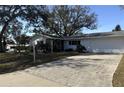 Charming single-story home featuring a large driveway, mature trees, and an attached two-car garage at 2040 Pine Ridge Dr, Clearwater, FL 33763