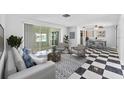 Bright living room boasts stylish decor, tile floors, and sliding glass doors to enclosed patio at 2762 W Vina Del Mar Blvd, St Pete Beach, FL 33706