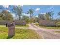 Open gate leading to a lush drive and large front yard at 3864 Gocio Rd, Sarasota, FL 34235