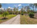 Long gravel driveway leading through a lush green front yard at 3864 Gocio Rd, Sarasota, FL 34235