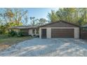 Low angle shot of home's exterior with garage and mature landscaping at 3864 Gocio Rd, Sarasota, FL 34235