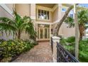 Inviting front entrance with detailed glass doors, paver walkway, and lush tropical plants at 7460 Monte Verde, Sarasota, FL 34238