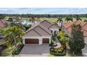 Beautiful home features a paver driveway, tile roof, manicured landscaping, and two-car garage at 15608 Leven Links Pl, Lakewood Ranch, FL 34202