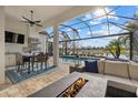 Covered patio view of beautiful pool and lake with outdoor kitchen and seating at 15608 Leven Links Pl, Lakewood Ranch, FL 34202