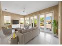 Bright living room featuring tile floors, neutral walls, large windows, and stylish furniture at 5521 Bilbao Pl, Sarasota, FL 34238