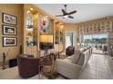 Cozy living room with custom built-ins, display shelving, and serene water views from the adjacent lanai at 5521 Bilbao Pl, Sarasota, FL 34238