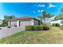 A single story house with a 2-car garage, tile roof, paver driveway and tropical landscaping at 15917 Clear Skies Pl, Lakewood Ranch, FL 34211