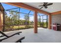 Spacious screened lanai with outdoor seating and a grill, perfect for enjoying the serene backyard views at 26720 Weiskopf Dr, Englewood, FL 34223