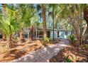 Charming single-story home with lush tropical landscaping and a brick walkway leading to the entrance at 4510 Banan Pl, Sarasota, FL 34242
