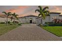 Beautiful one-story home at sunset featuring well-manicured landscaping and a neutral color scheme at 4745 Benito Ct, Lakewood Ranch, FL 34211