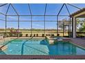Screened-in pool with spa and view of lush greenery and other homes in a sunny neighborhood at 4745 Benito Ct, Lakewood Ranch, FL 34211