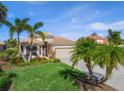 Charming single-story home with lush landscaping, palm trees, and a well-manicured lawn at 531 Latitude Ln, Osprey, FL 34229