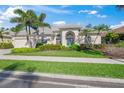 Charming single-story home with lush landscaping, blue front door and a paver driveway at 557 Marsh Creek Rd, Venice, FL 34292