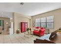 Cozy living room showcasing a red sofa, decorative accents, and natural lighting from a window at 9214 Raes Creek Pl, Palmetto, FL 34221