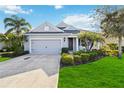 Inviting single-story home featuring a two-car garage, tidy landscaping, and a well-maintained front lawn at 10931 Blue Magnolia Ln, Parrish, FL 34219