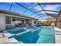 Covered pool features a jacuzzi and lounge chairs, perfect for enjoying the outdoors year-round at 5035 Seafoam Trl, Bradenton, FL 34211