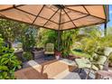 Cozy outdoor patio features a grill, comfortable seating, and lush greenery, perfect for relaxing and entertaining at 7453 Featherstone Blvd, Sarasota, FL 34238